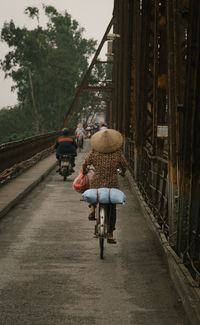 Rear view of woman riding bicycle on road