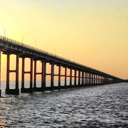 Pier in sea at sunset