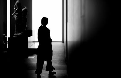 Rear view of silhouette woman standing in corridor