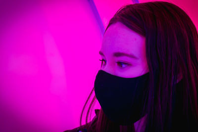 Close-up portrait of young woman against pink wall
