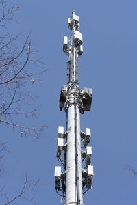 Low angle view of communications tower against clear blue sky