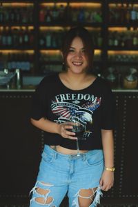 Portrait of smiling young woman standing at night