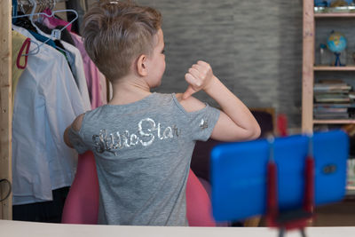 Rear view of boy standing at home