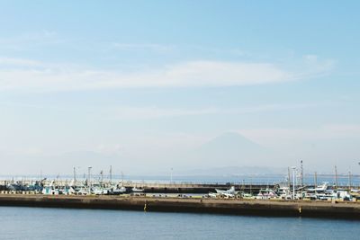 Boats moored at harbor against sky