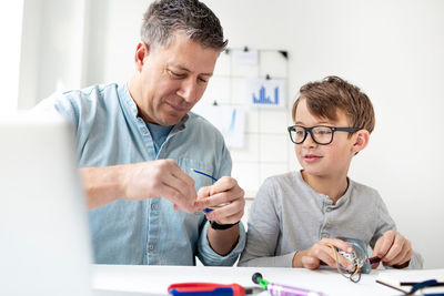 Boy looking at camera while sitting on table