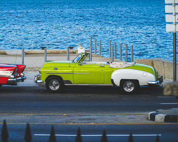 Car parked on street by sea in city