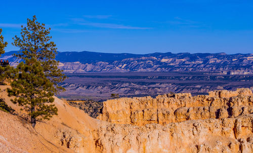 Scenic view of mountains against blue sky