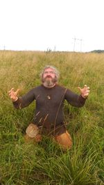 Full length of man with arms raised on field