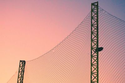 Low angle view of telephone pole against sky during sunset