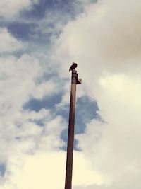 Low angle view of pole against cloudy sky