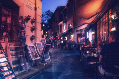 People on illuminated street at night