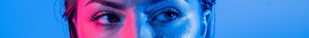 Panoramic shot of woman looking away against blue background