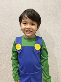 Portrait of smiling boy standing against wall