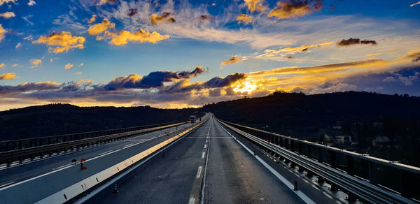 Highway against sky during sunset