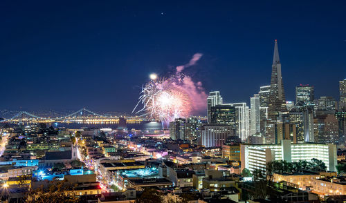 Illuminated cityscape against sky at night