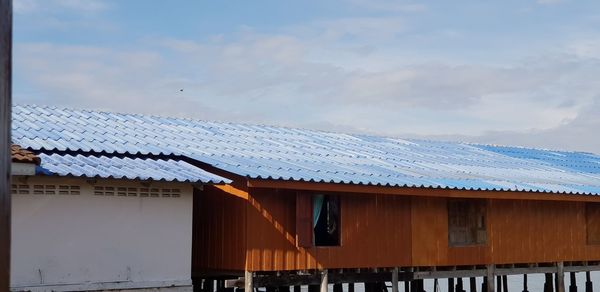 Low angle view of house roof against sky