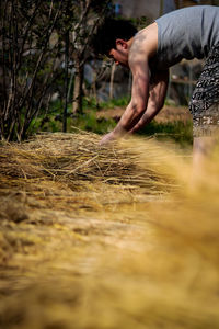 Midsection of man on field in forest