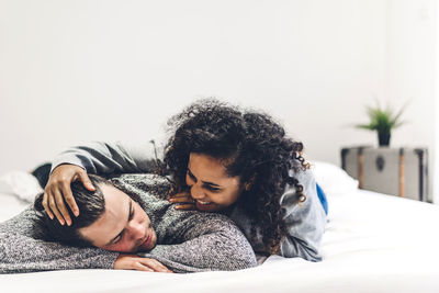 Romantic couple embracing while lying on bed