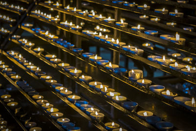 Full frame shot of illuminated tea lights at church
