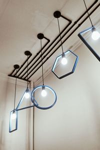 Low angle view of illuminated light bulb hanging from ceiling