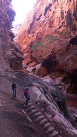 Rear view of people walking on mountain during winter