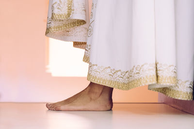 Low section of woman standing on floor at home