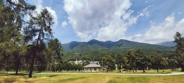 Scenic view of trees and houses against sky