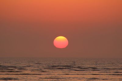 Scenic view of sea against orange sky