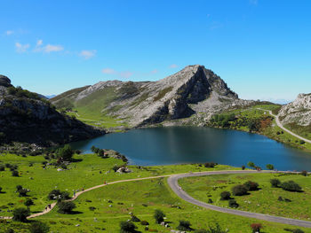 Scenic view of lake and mountains against clear blue sky