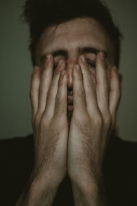 Portrait of european man with hand covering face and thinking. male in shirt looking worried.