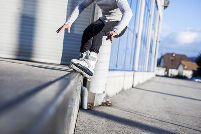 Low section of young man doing a trick on inline skates