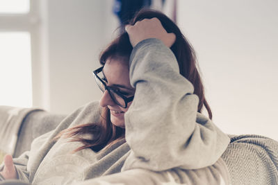 Close-up of woman relaxing on sofa at home