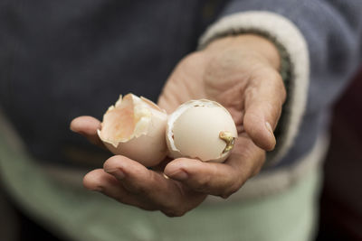 Close up of villager holds hatched egg shell