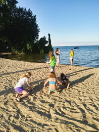 People at beach against sky