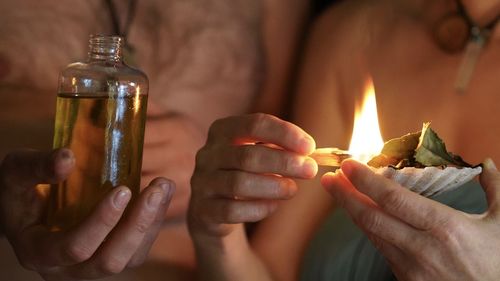 Midsection of woman holding burning candle