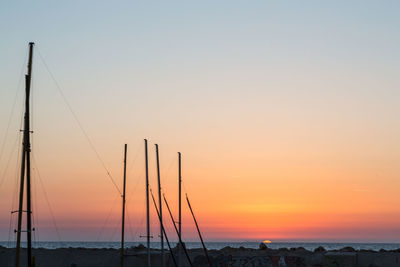 Sailboats in sea against sky during sunset