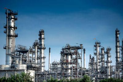 Low angle view of illuminated factory against sky