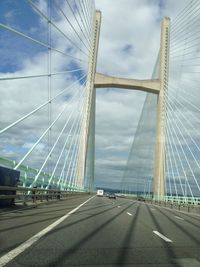 Bridge over road against cloudy sky