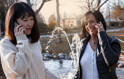 Close-up of colleague talking on phone outdoors