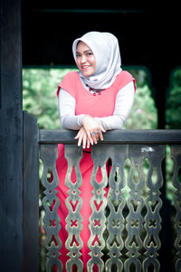 Portrait of cute girl sitting on railing