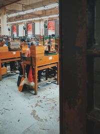 Rear view of people working on table