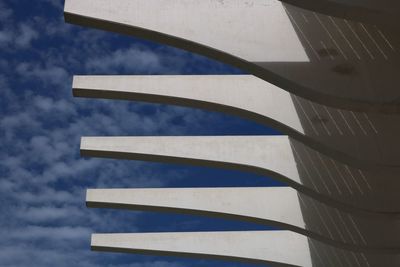 Low angle view of modern building against cloudy blue sky