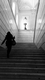 Low angle view of person walking on staircase in building