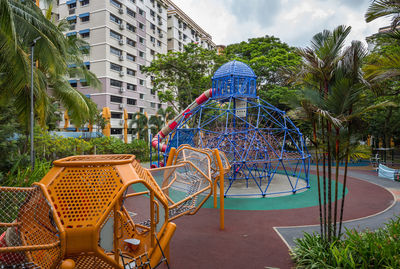 Chairs by swimming pool against buildings in city
