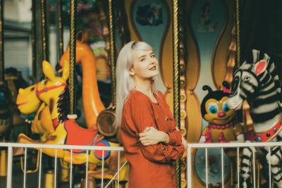 The girl standing near the carousel