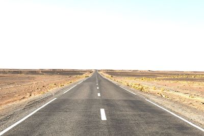 Road passing through landscape against clear sky