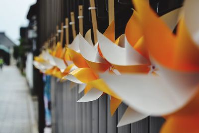 Close-up of pinwheel toys tied on railing in city