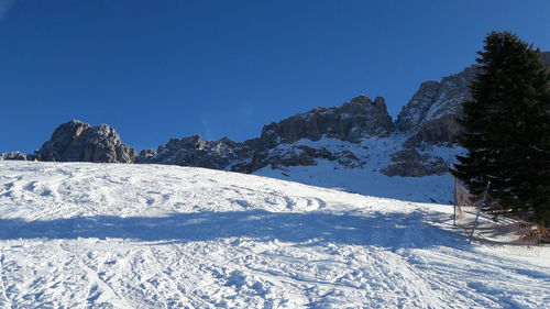 Scenic view of snowcapped mountains against clear blue sky