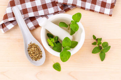 Close-up of herb in mortar and pestle on table