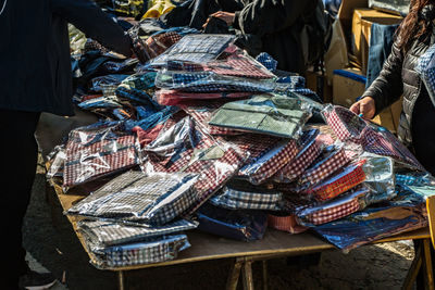 People buying shirts in market